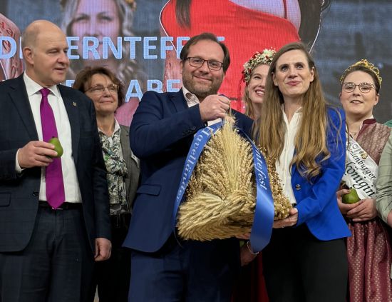 Mehrere Personen mit kleiner Erntekrone als symbolischen Staffelstab
